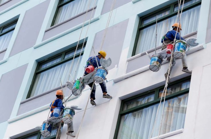 Professionals painting building